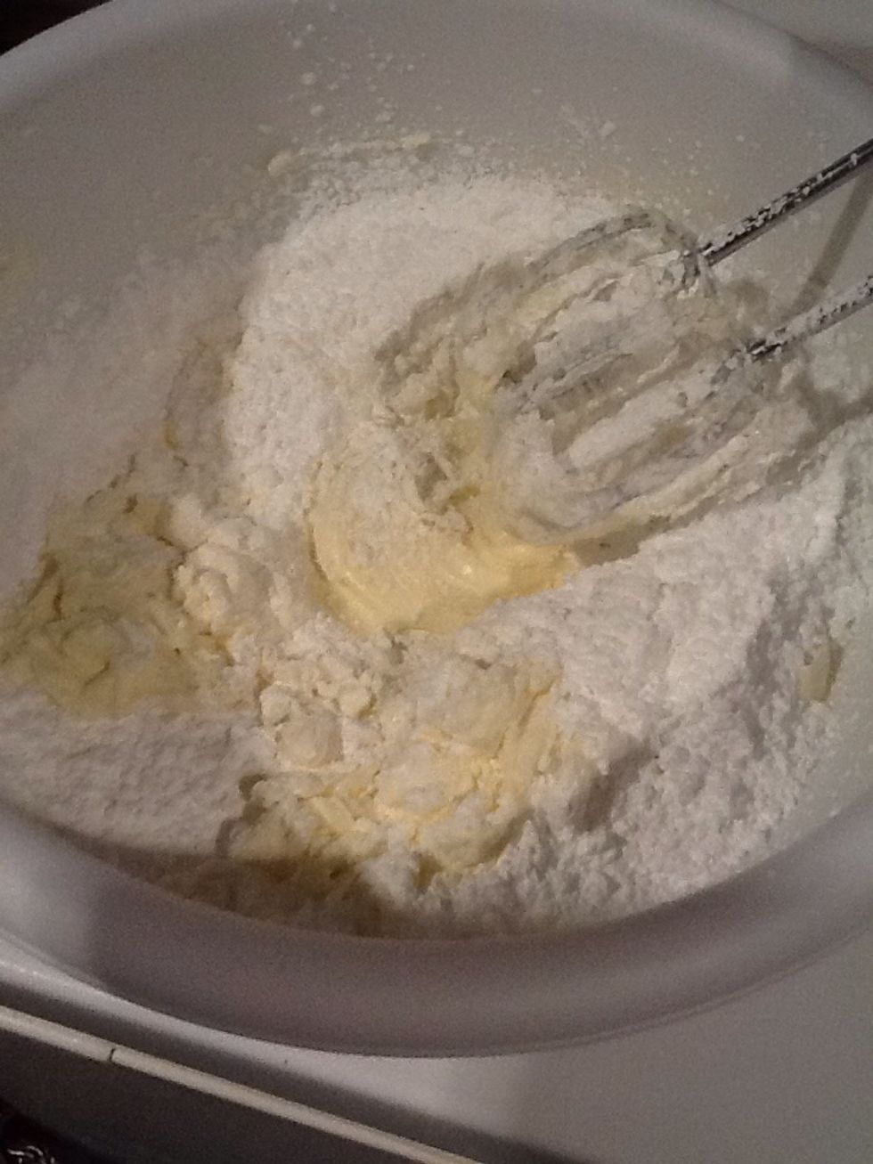 Add your powdered sugar. Make sure you sift it so there's no lumps in the final product! Mix until its completely incorporated. Scrape the sides of the bowl.
