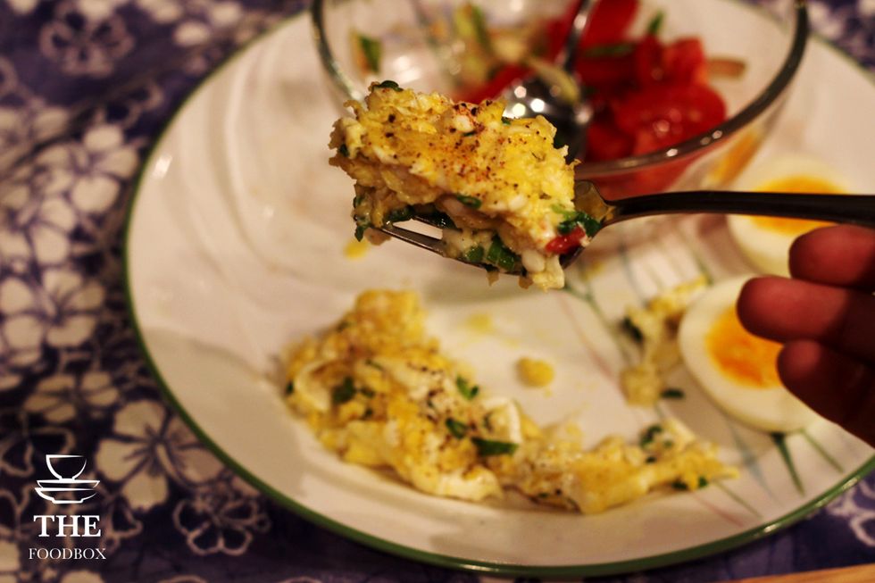 Add your scrambled eggs into the spring mix and tomatoes.