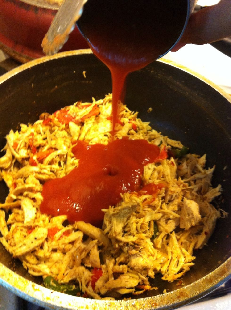 Add your tomato sauce and with your can of tomato sauce add two cans of water to your chicken