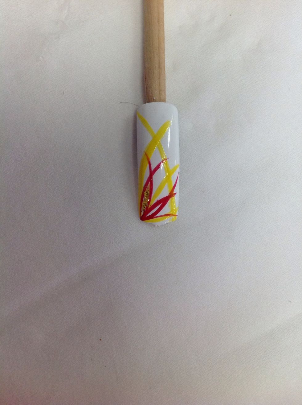 Added gold glitter using a gold glitter striping pen in between where the red stripes cross.