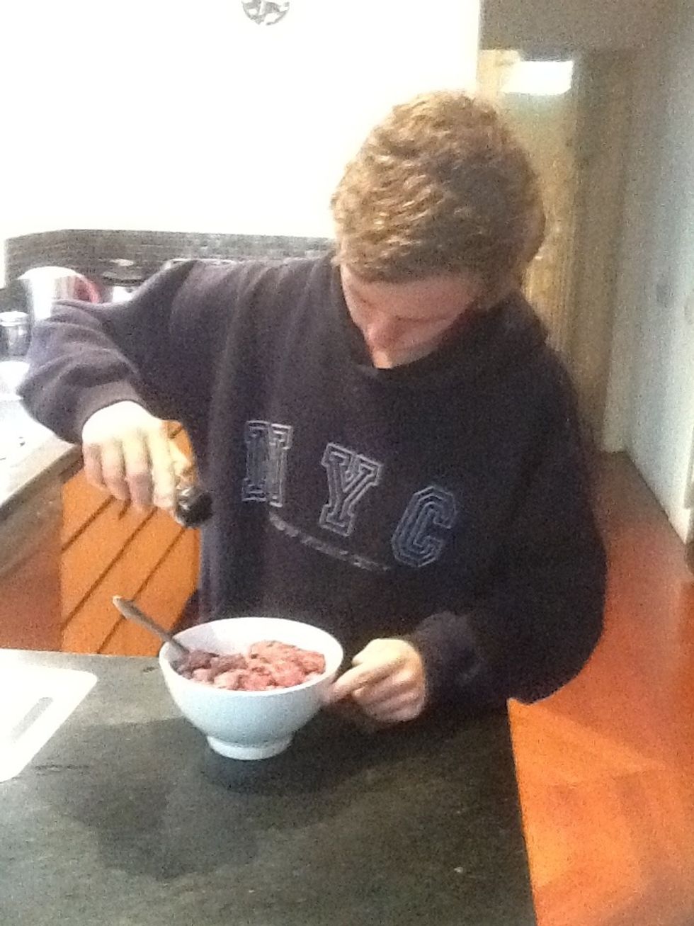 Adding herbs, garlic and lemon to the meat for seasoning