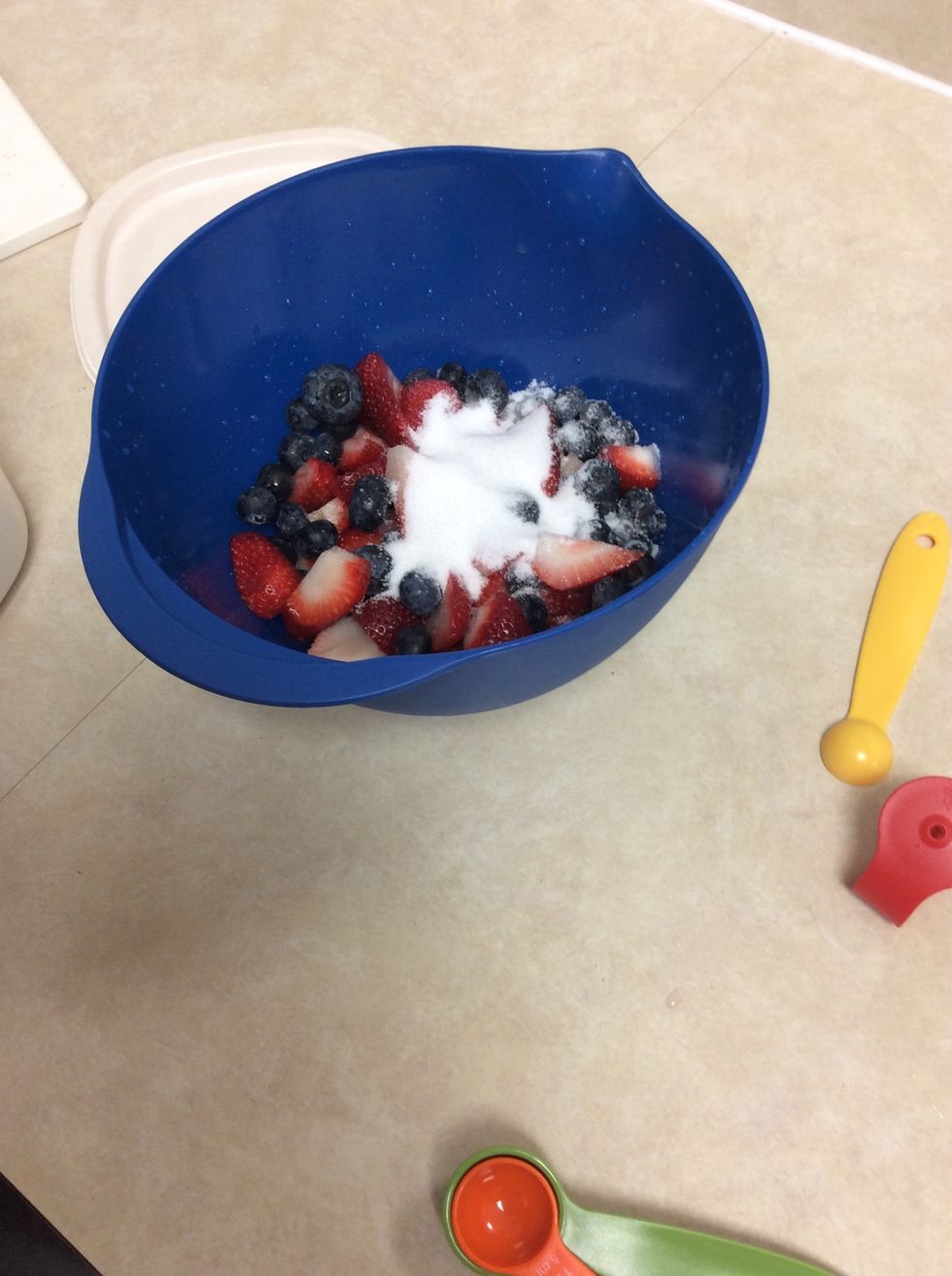 Adding Strawberries, Blueberries, and Sugar together.