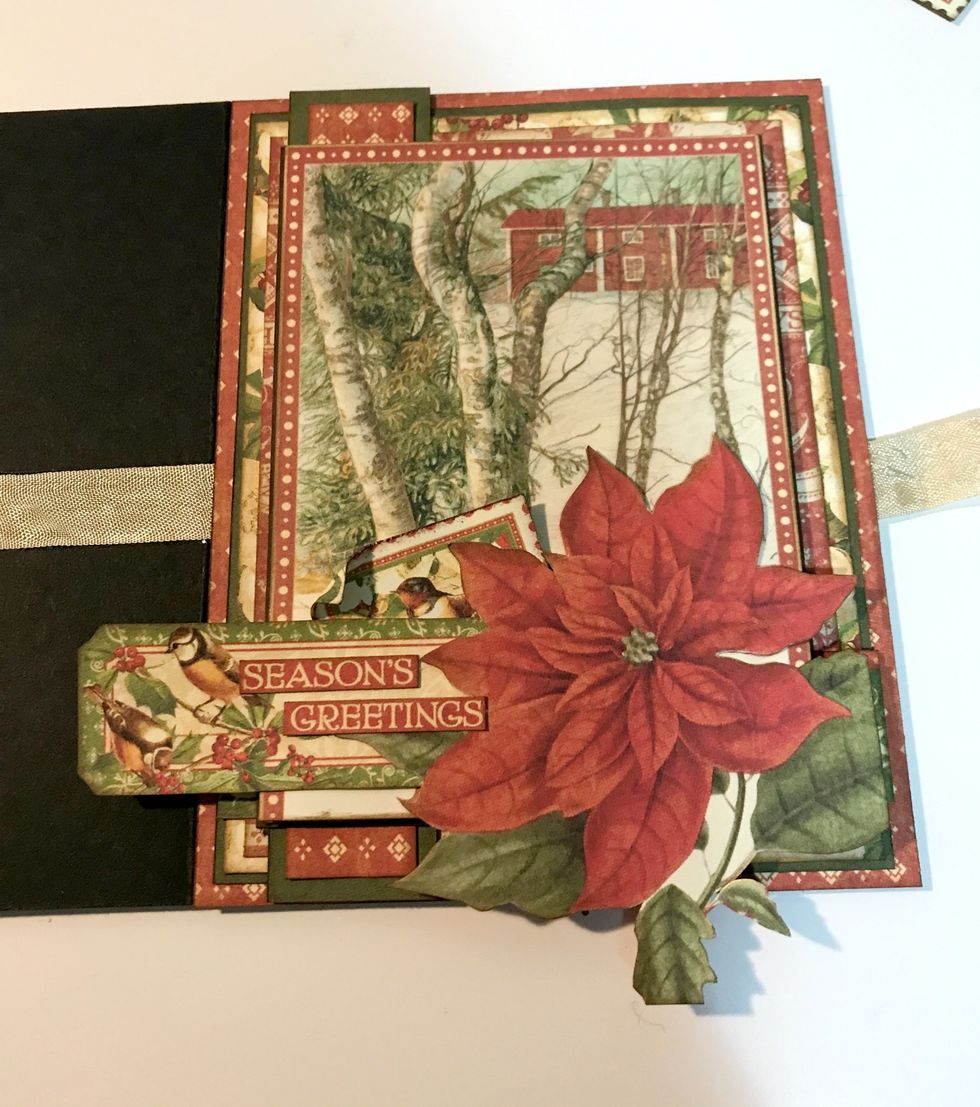 Adhere a fussy cut poinsettia in bottom right corner of image. Adhere bird ticket to left of poinsettia, sitting slightly underneath it. Adhere a stamp underneath & to the left of the poinsettia.