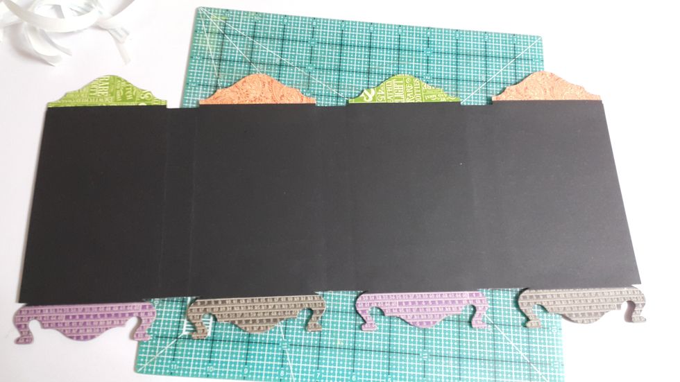 Adhere another black cardstock to cover all panels and trim the corners into shapes
