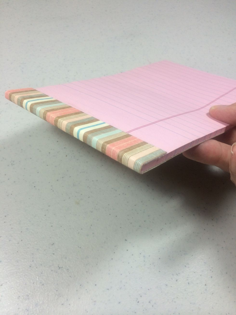 Adhere it to the top of the steno pad and fold over excess to the back side.