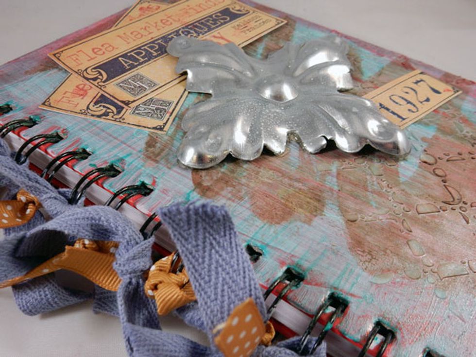 Adhere metal embellishment to center of front cover. Spritz with Ice Fairy Dust.