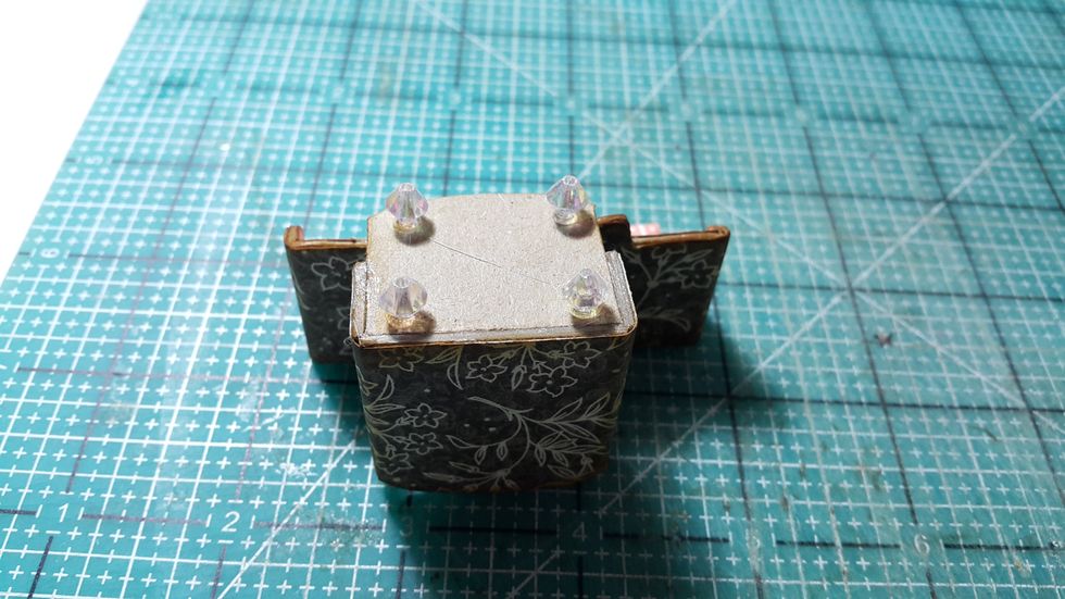 Adhere on beads as feet for the sofas, if you would like to have a fluffy seats, cut chipboards and do the same as what you did for the dining chairs.