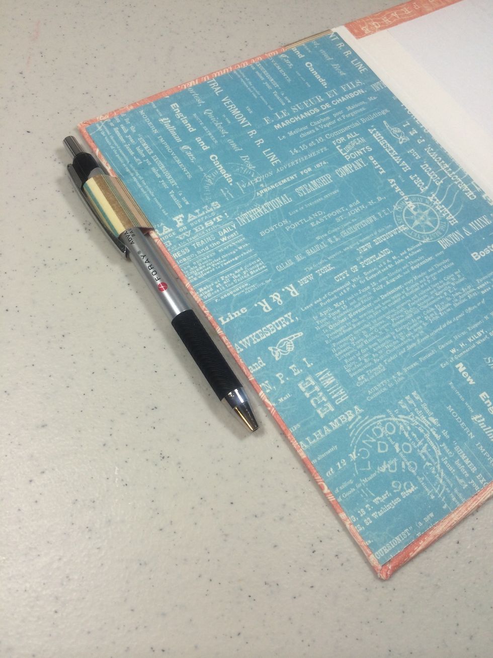 Adhere one of the two large papers to the left interior page where the pen holder is.