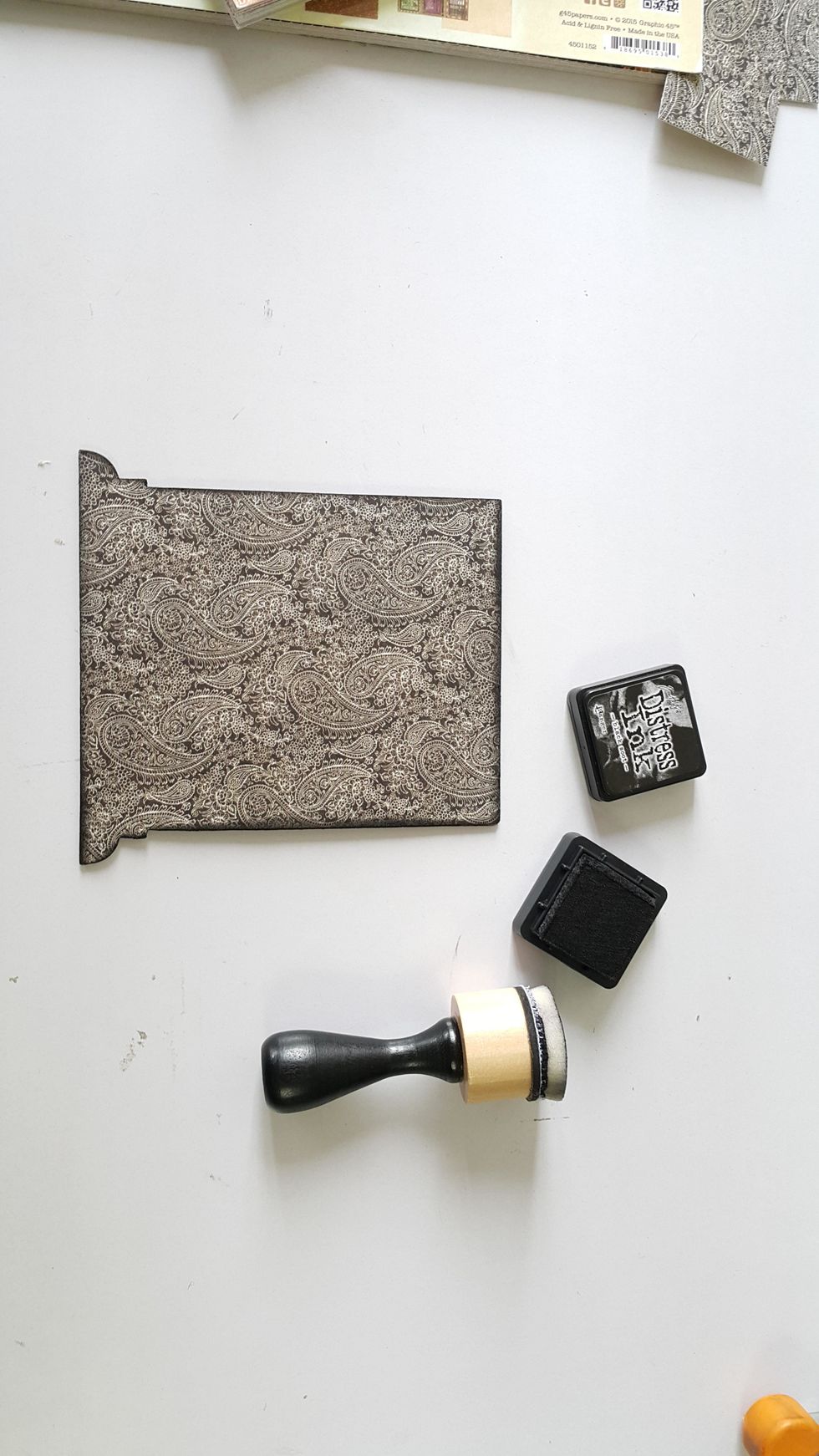Adhere pattern papers on both sides of the back chipboard piece, apply distress ink on the edges