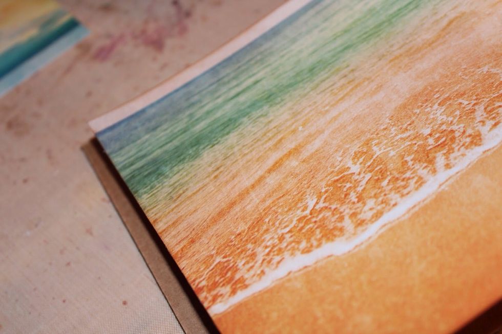 Adhere patterned paper to corrugated board.