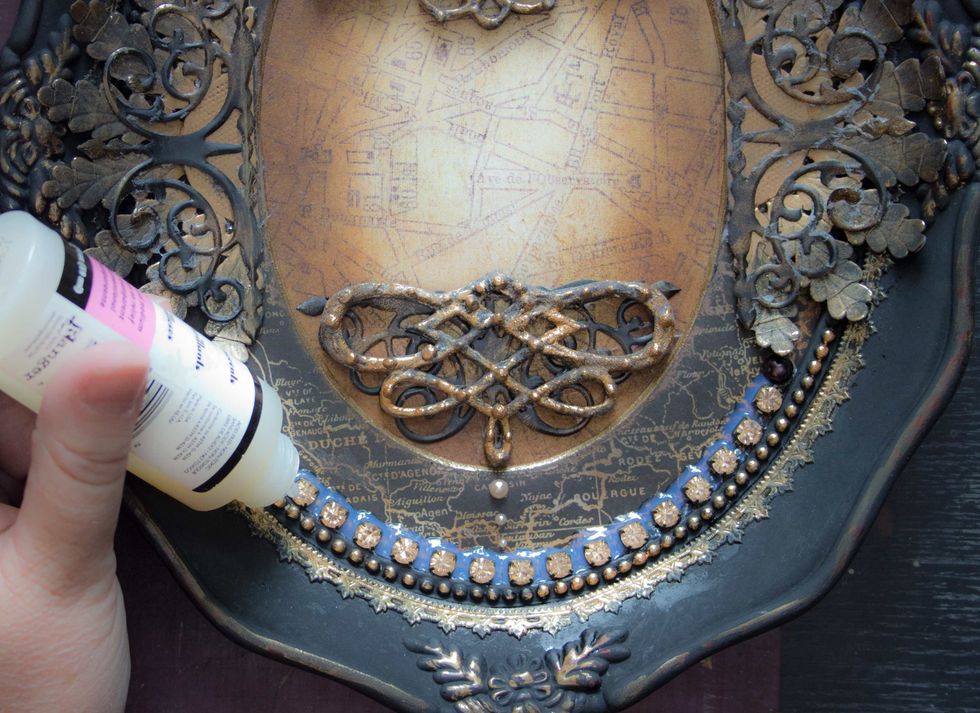 Adhere rhinestone chain around the inner opening of the frame, then add a layer of Glossy Accents and Micro Beads between each gem: