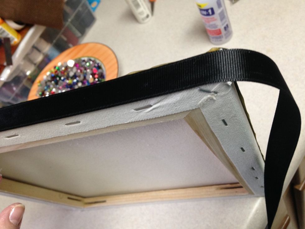 adhere ribbon around edges of canvas to cover edges of metal.