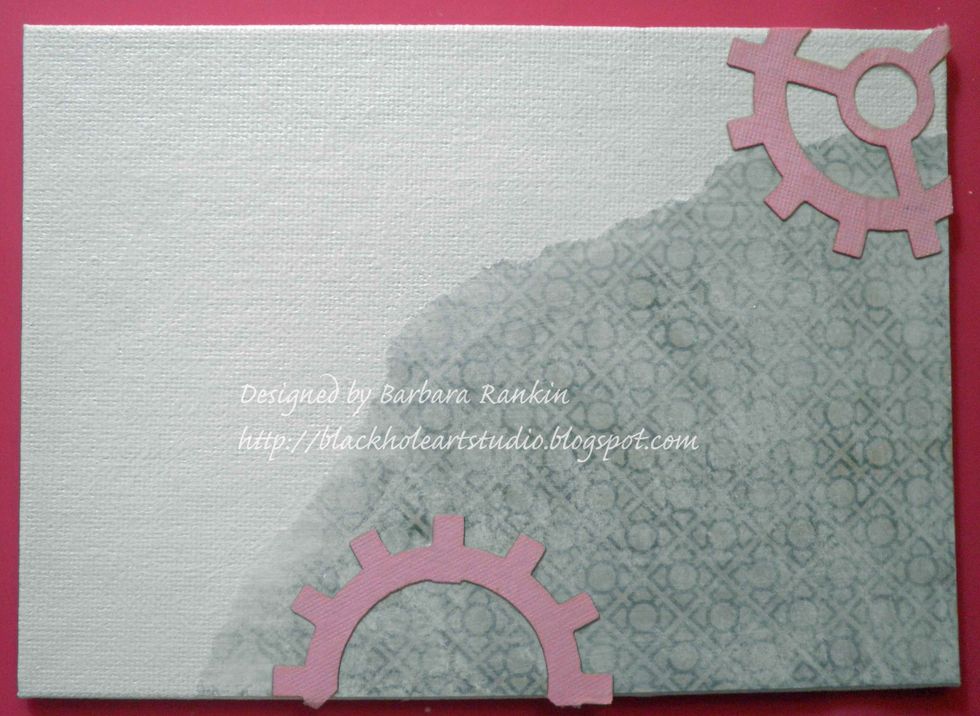 Adhere Sin City Stamps laser cut gear shapes to canvas with matte medium.