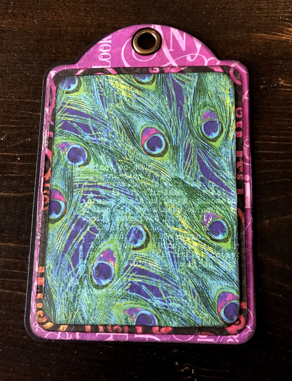 Adhere the 3 1/2" swirly paper to the tag. Adhere the peacock paper to the 3 1/2" swirly paper.