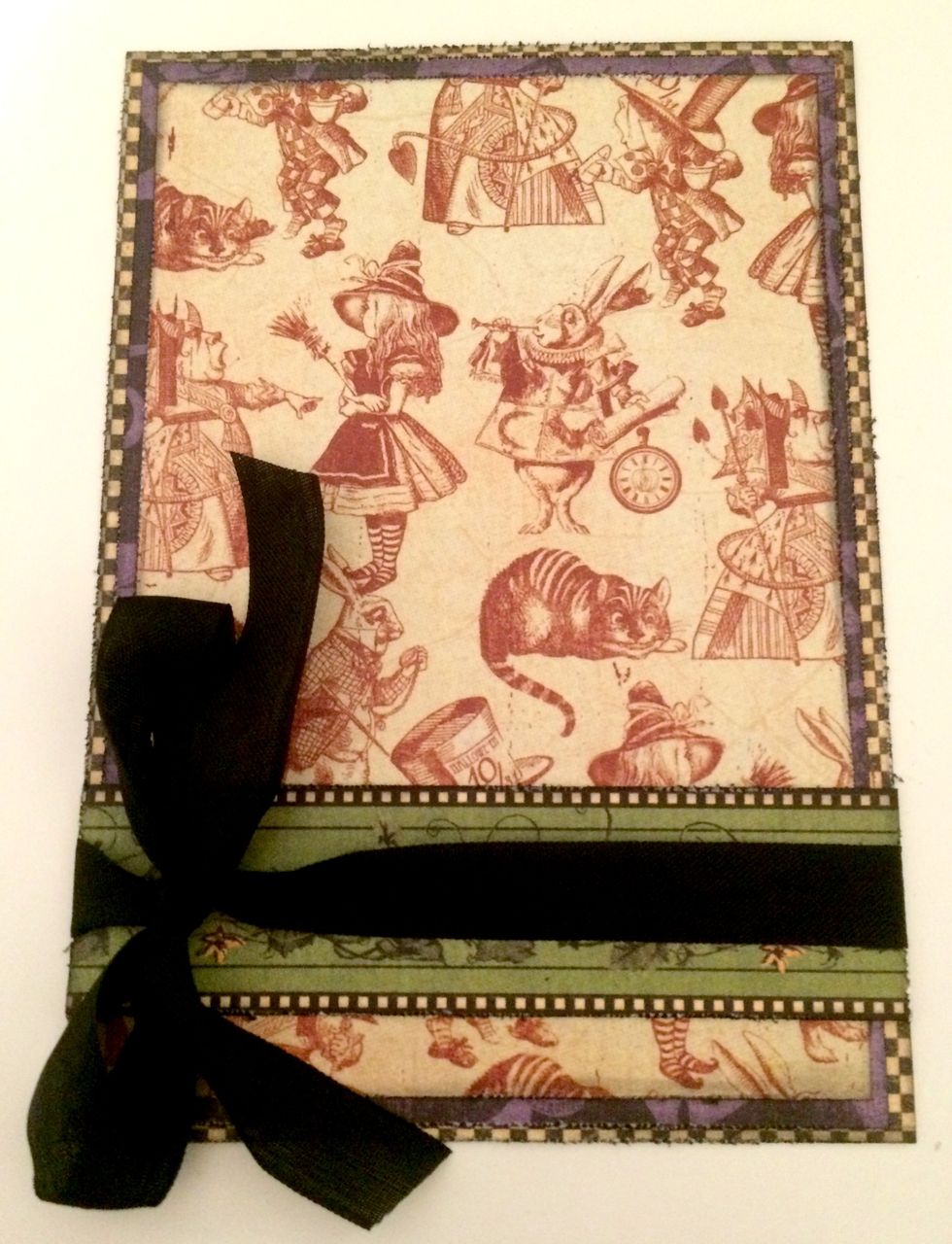 Adhere the 4 3/4" long pumpkin border 3/4" from the bottom of the checker paper. Wrap black ribbon around the middle of the pumpkin border and tie a bow on the left hand side.