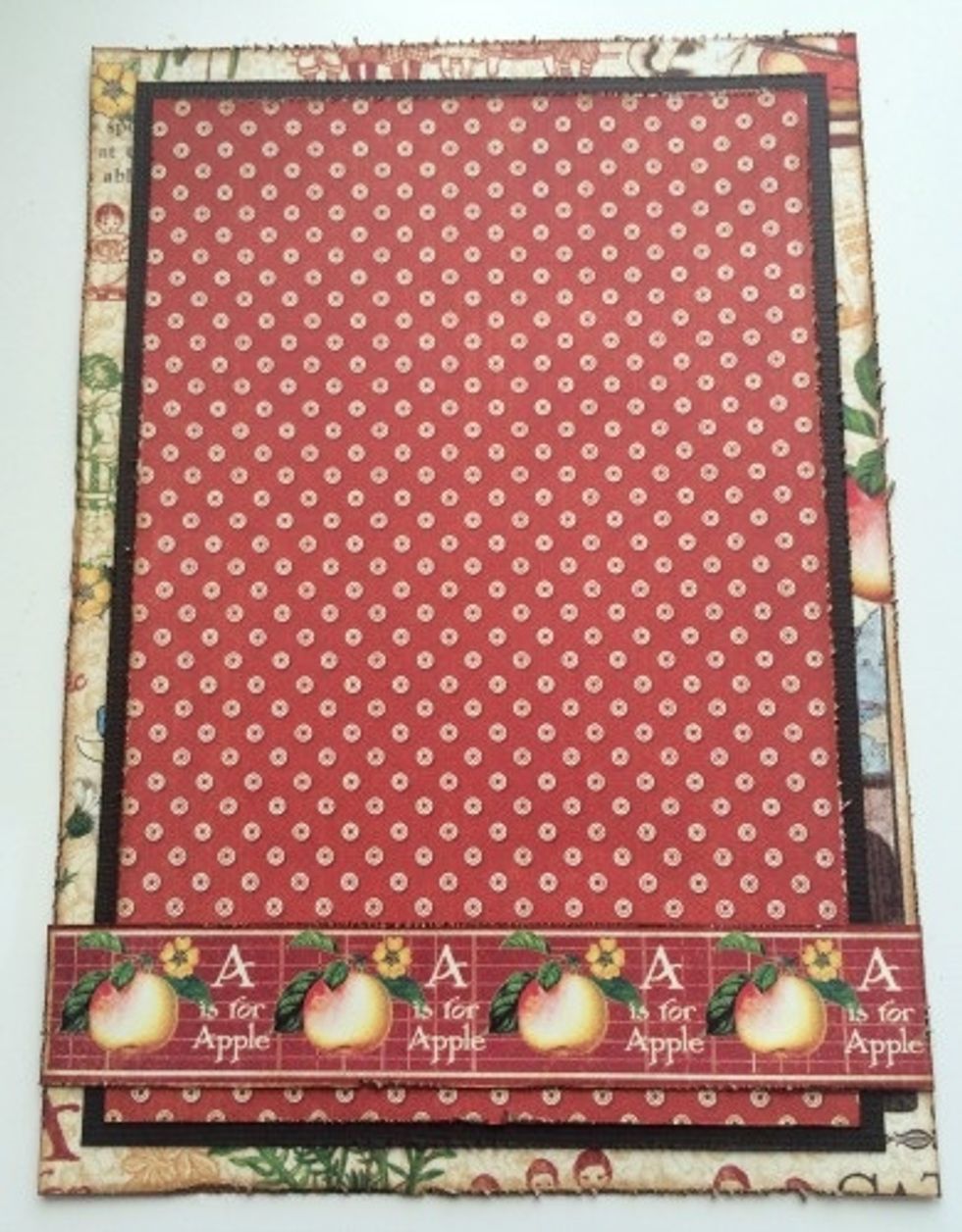 Adhere the apple border a 1/4" above the bottom of the red and white dot paper. The border will stretch all the way across the patterned paper.