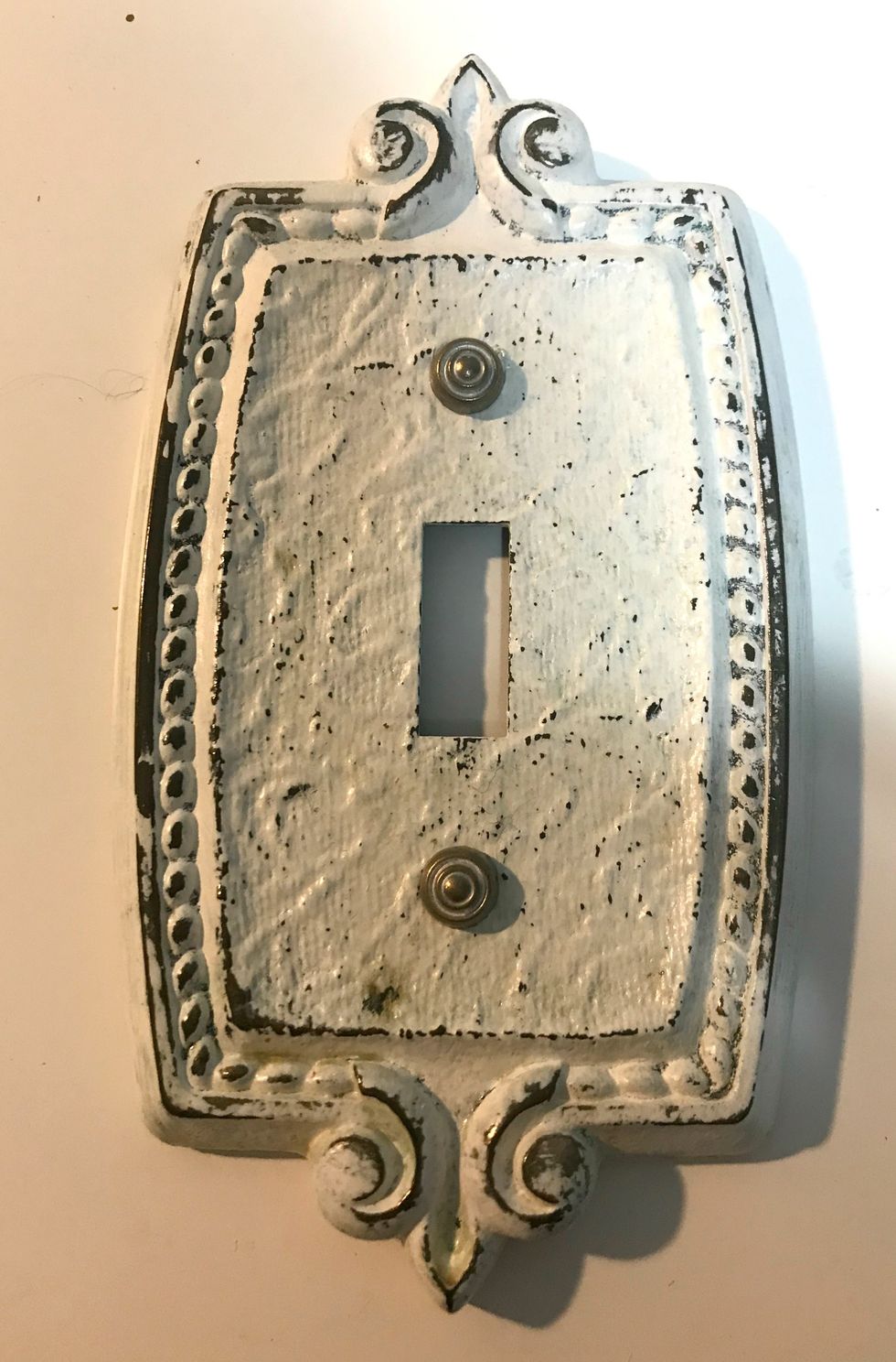 Adhere the brads to each hole on the light plate cover.