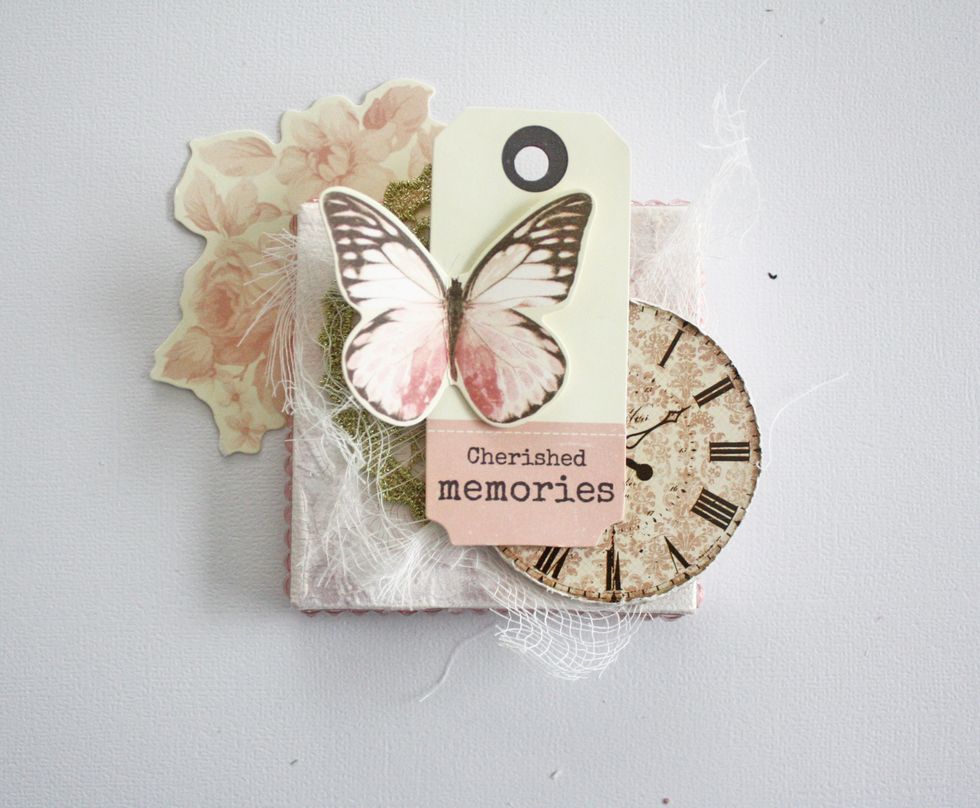 Adhere the clock then the tag. On top of the tag glue the butterfly.