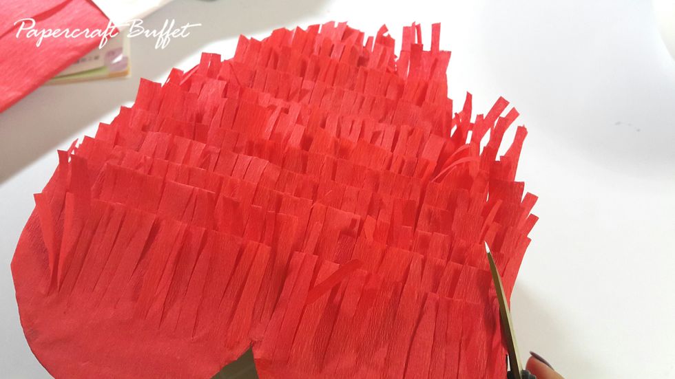 Adhere the crate paper on the front and back of the heart Pinata, trim the excess.