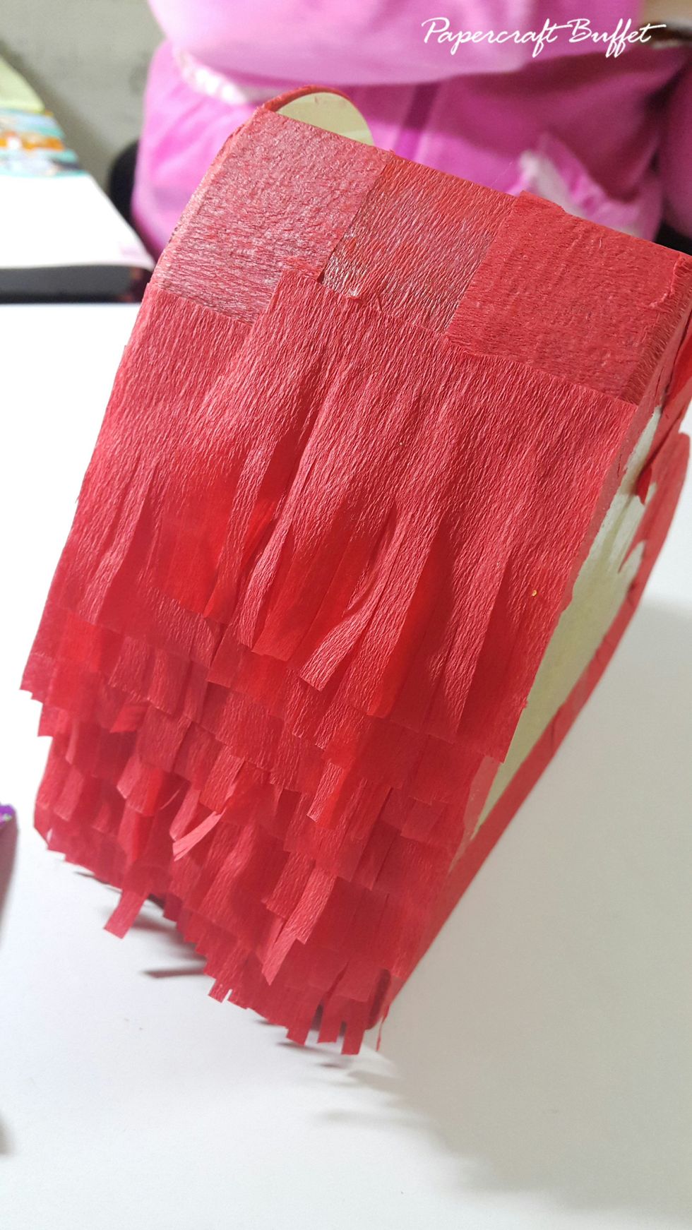 Adhere the crate paper on the sides of the heart Pinata.