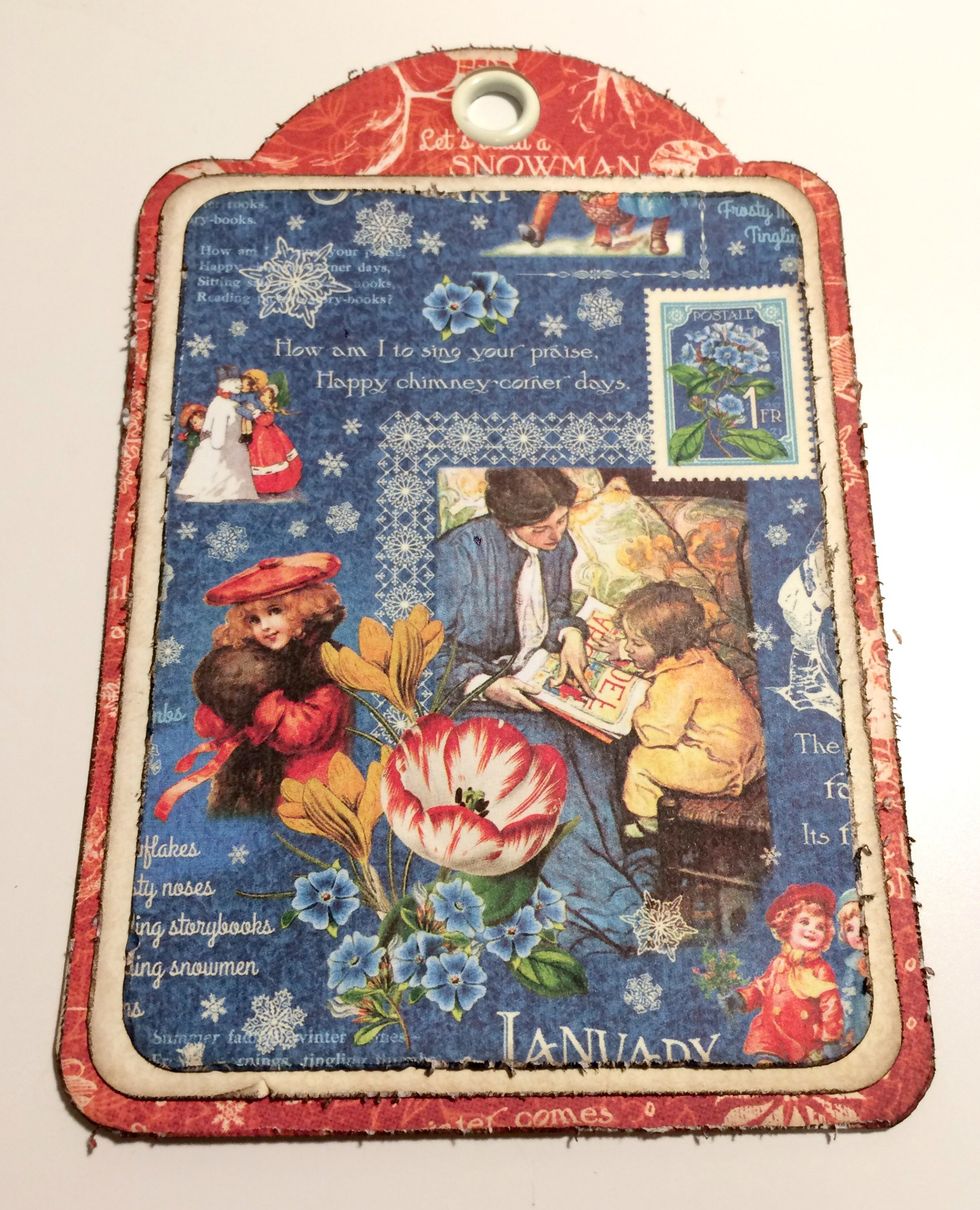 Adhere the cream paper to the red patterned paper tag. Adhere the blue January patterned paper to the cream paper.