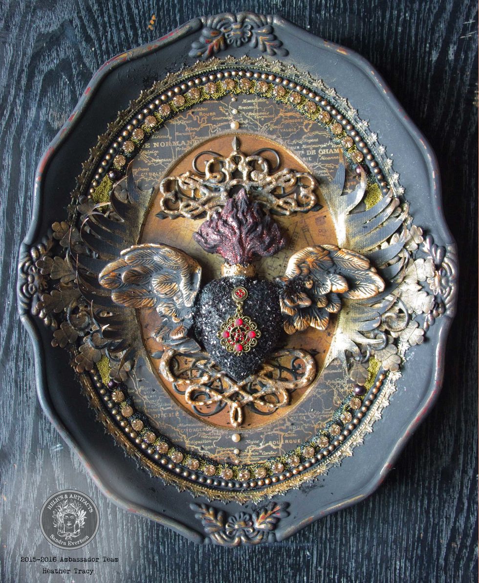 Adhere the feathery shapes, tip and edge them with "Steampunk Copper". Use heavy-duty adhesive and a bit of layered card-stock to affix the Relics within the frame: