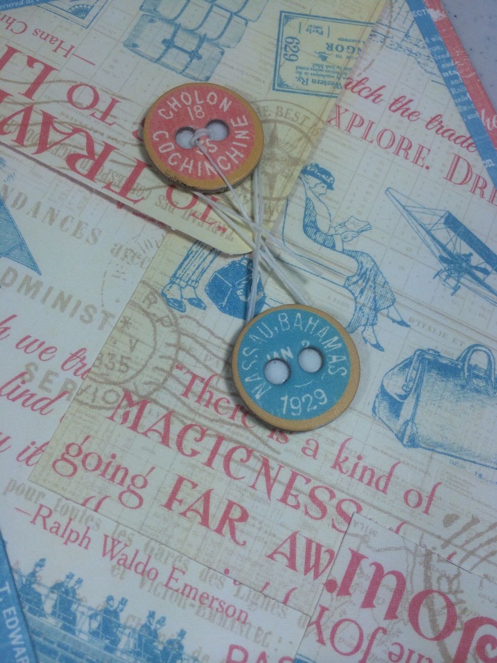 Adhere the first button to the envelope flap. Then add foam tape to a second chipboard button and adhere to the envelope as shown. Wrap the twine in an 8 fashion around the buttons to secure.