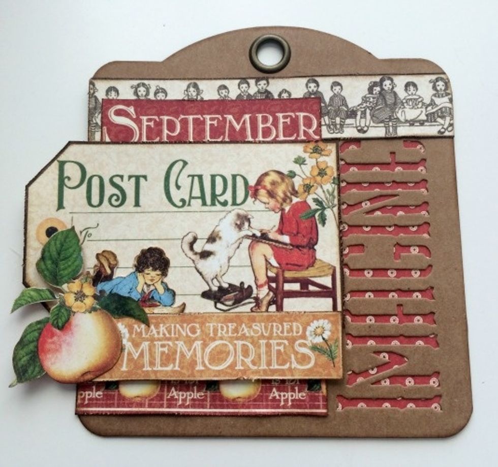 Adhere the girl reading to the left of the cat and at the bottom of the post card. Use a couple of foam squares to adhere the apple to the left of the making memories sentiment.