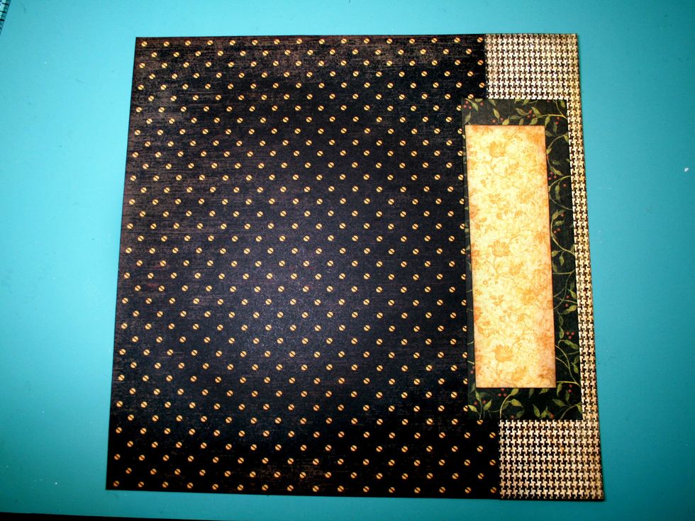 Adhere the larger dark strip about 3/8" from the right side of the page and 1 7/8" from the bottom. Adhere the gold strip over top about 1" from the side of the page & 2 5/8" from the bottom as shown
