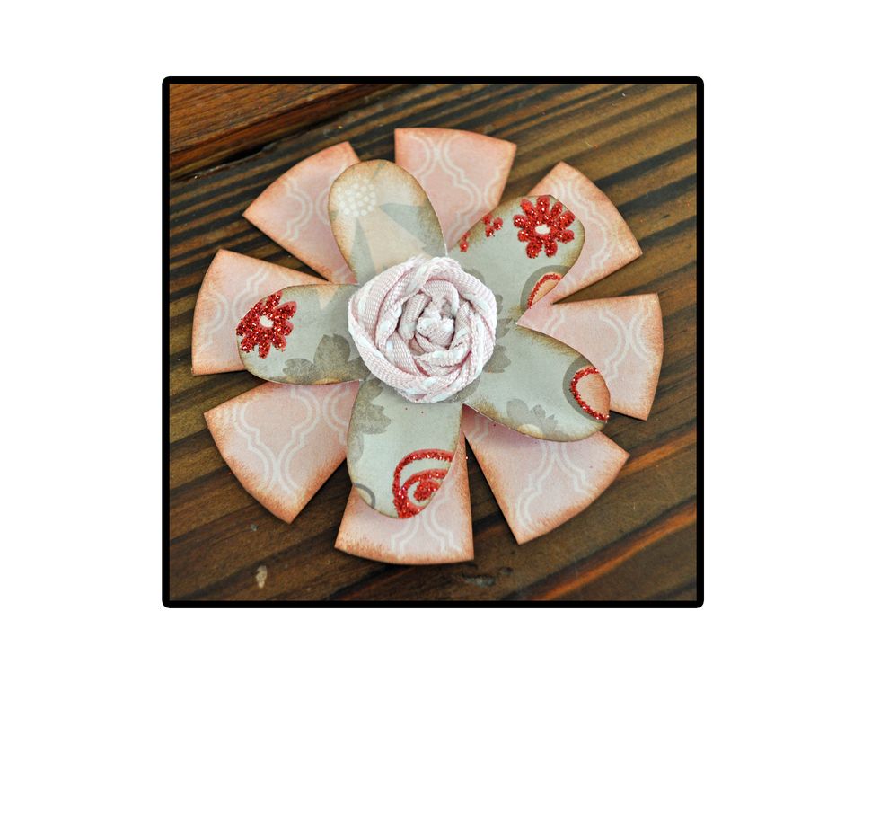 Adhere the layers of your flower together and add a center. Use buttons, brads or ribbon. If you like the ribbon one above, make sure to check out our Make a Ribbon Center for Paper Flowers guide.