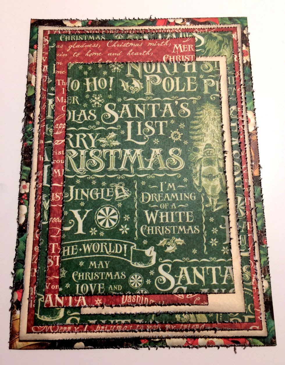Adhere the medium green word paper to the middle of the cream and red word patterned paper.