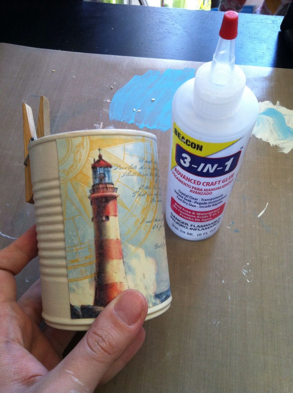 Adhere the paper to the tin, using a strong, faster drying adhesive.