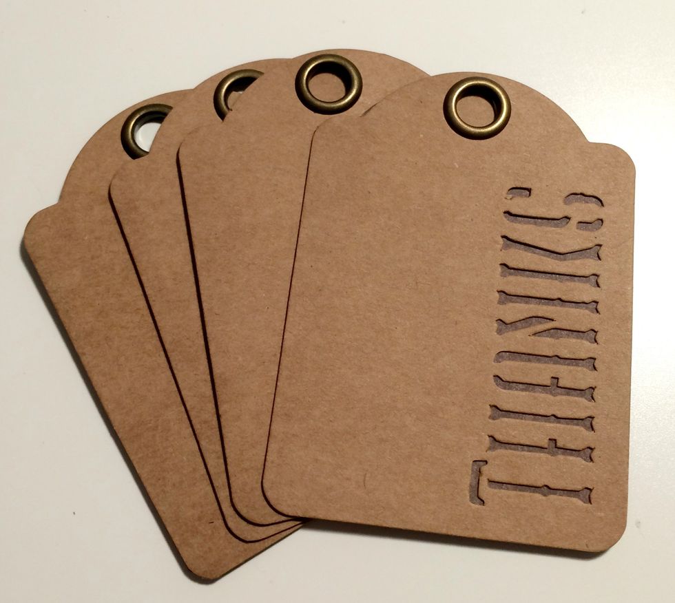 Adhere the plain brown side of the cut paper tags to the back of four thanks tags. You'll have the brown dot side of the paper showing on the back of the Thanks tag.