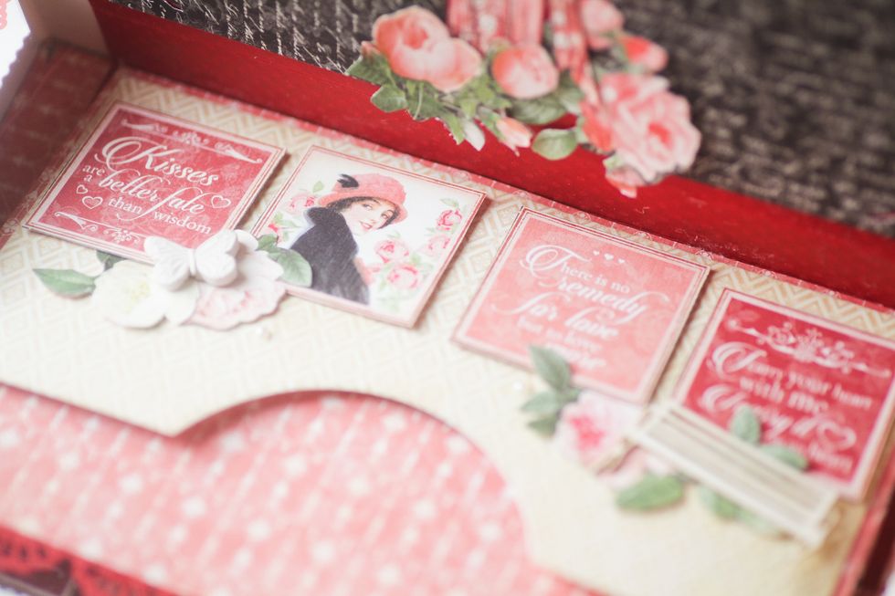 Adhere the pocket to one of the pages and embelish it with cut elements.