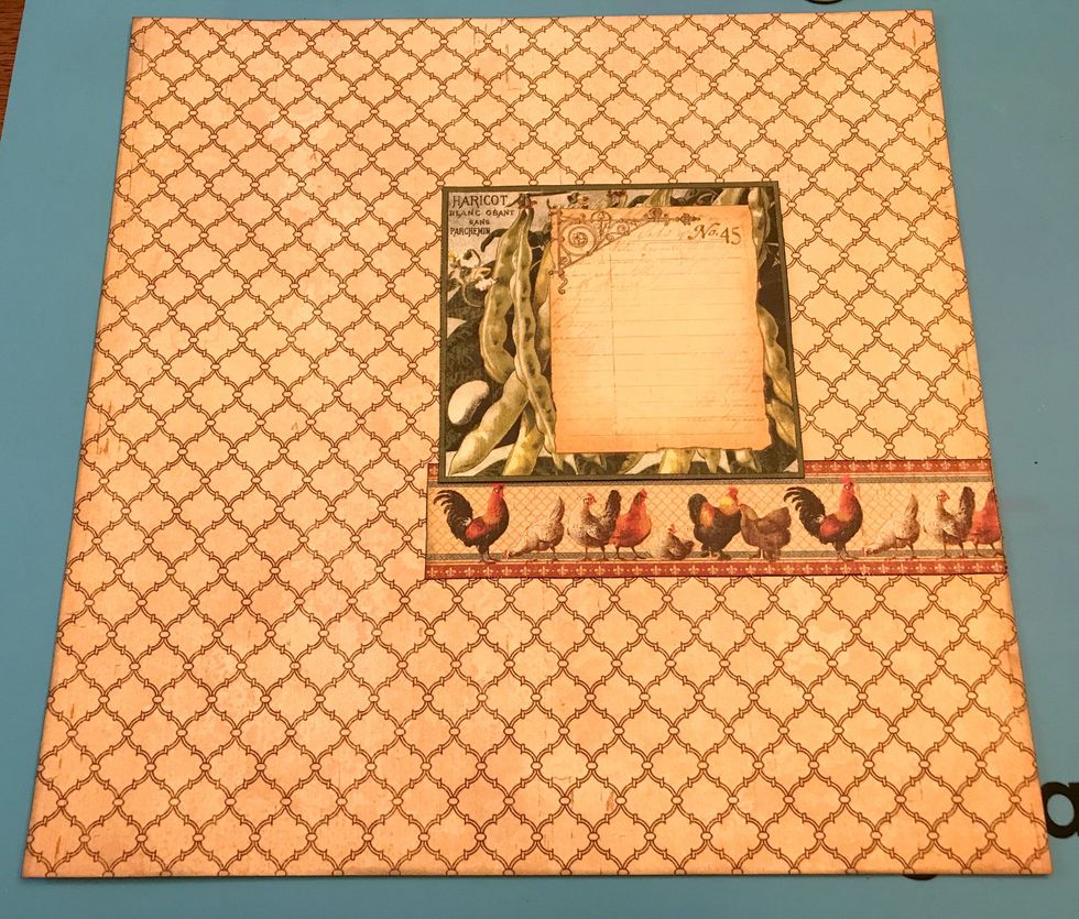 Adhere the rooster border 3 1/2" from the bottom of the lattice paper. Adhere the pea card 4" from the right of the paper and 1/4" over the rooster border.