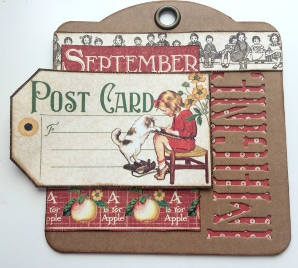 Adhere the September word 1/4" from the left of the tag and 1/2" from the top of the children border. Use foam squares to adhere post card slightly over the apple border and underneath the September.