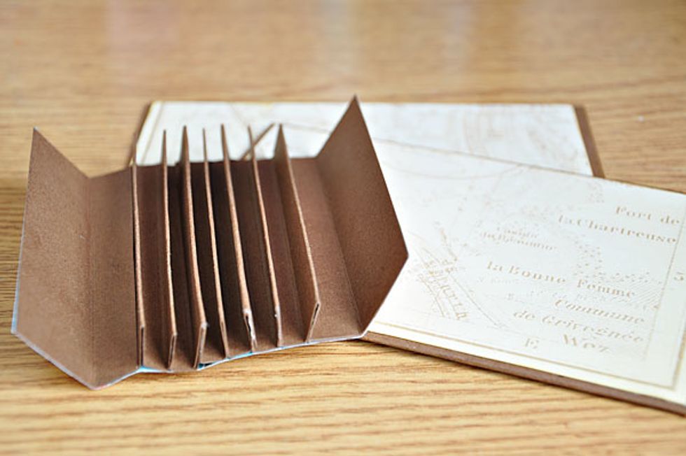 Adhere the spine to the covers. I opted to adhere from the outside instead of hiding the flaps inside. I think it is sturdier that way.