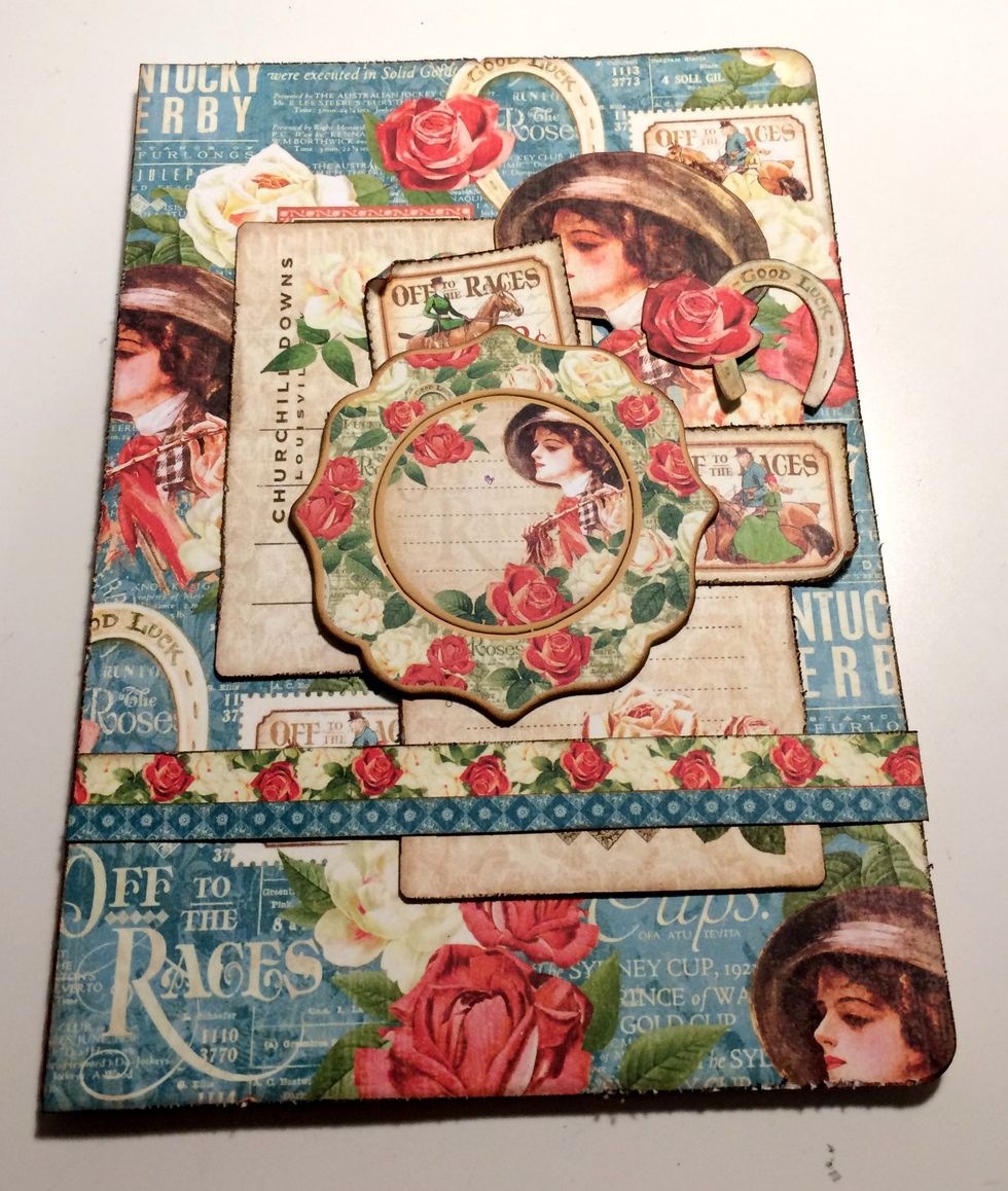 Adhere two postage stamps underneath the chipboard piece in the top right corner. Adhere the small horseshoe with rose beside the lady. Roll one of the corners either up or down on the stamps.