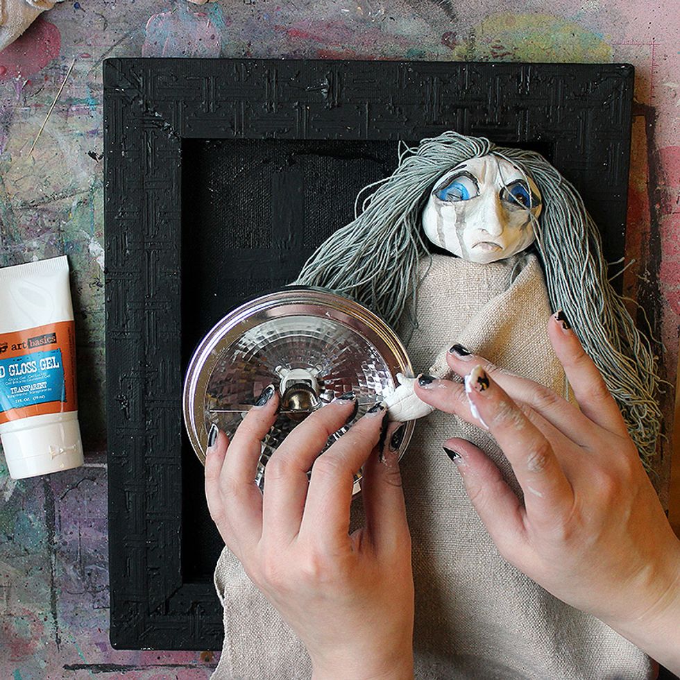 Adhere your doll and the main focal point to the canvas using 3D Gloss Gel.