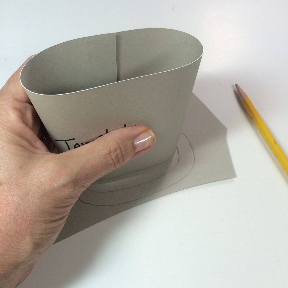 Adhere your original template closed with glue. While giving it a squeeze with one hand (to resemble the shape of a tote bag) create a template for the base by tracing onto scrap card stock.