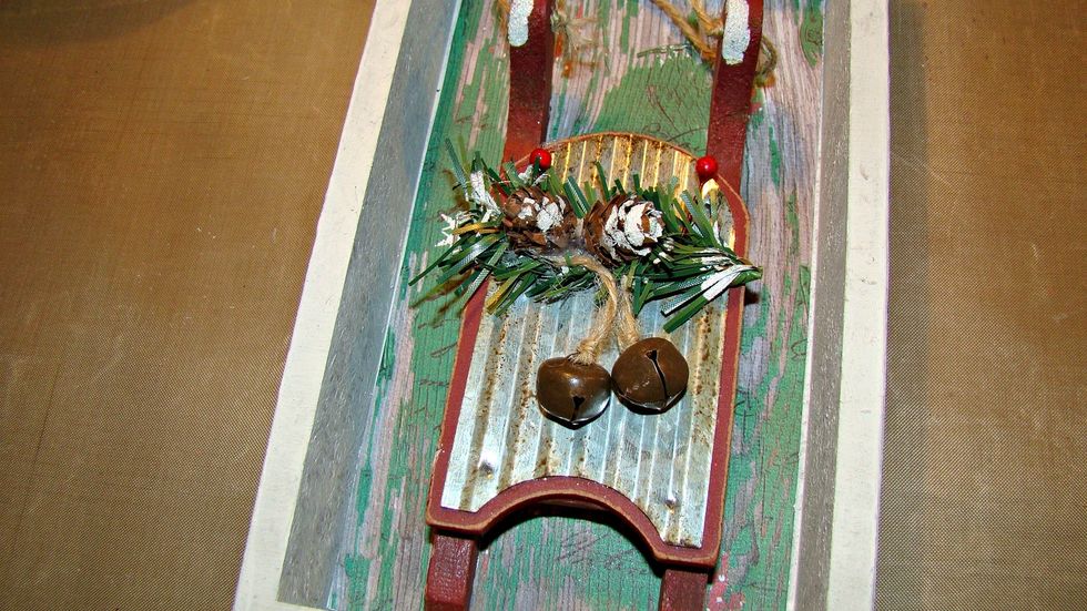 Adhere your ornament, add bells, greenery, pine cones etc.