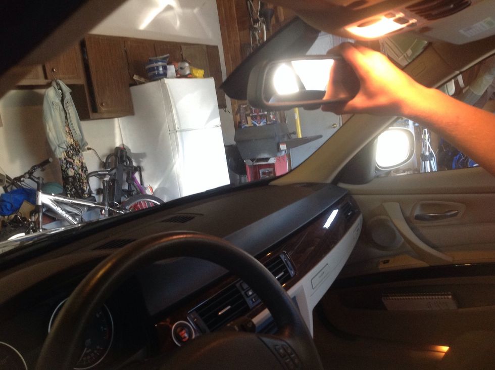 Adjust rear view mirror to see out of back of car