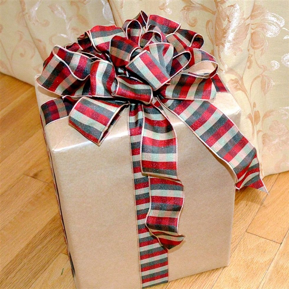 Adjust the loops to make a shapely bow and the cut the ends of the ribbon wrapped around the box. Use your hands to give a slight wave to the tail sections that dangle down the front of the box.