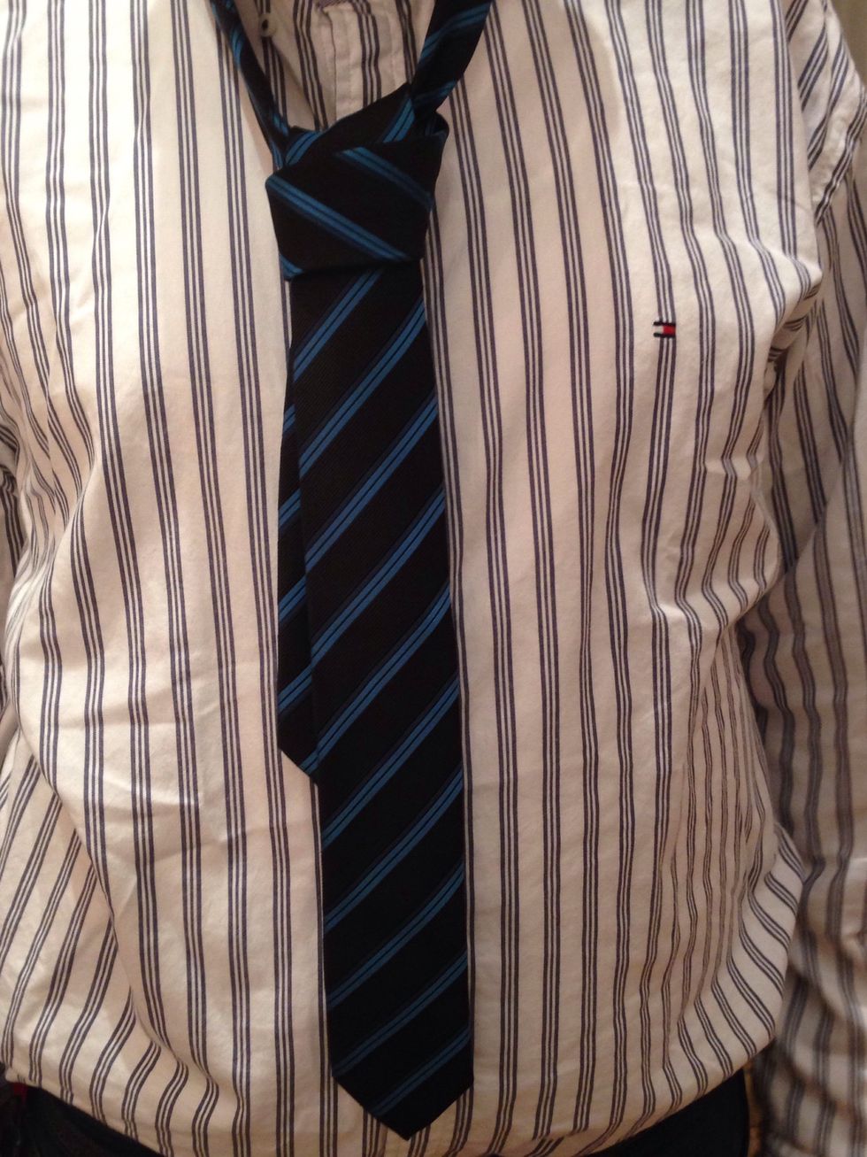 Adjust the position of the knot, holding it with one hand and pulling the narrow end with the other.