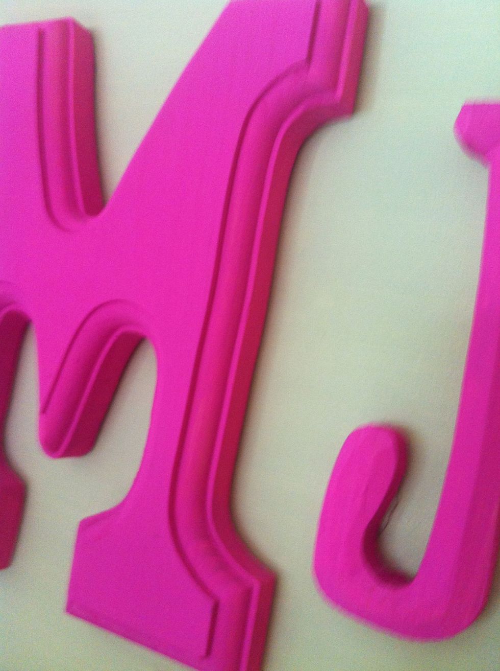 Affix the letters to the canvas using a hot glue gun. Be sure to apply them quickly or they will not stick. Flip your canvas and press on the backs to make the glue stronger.