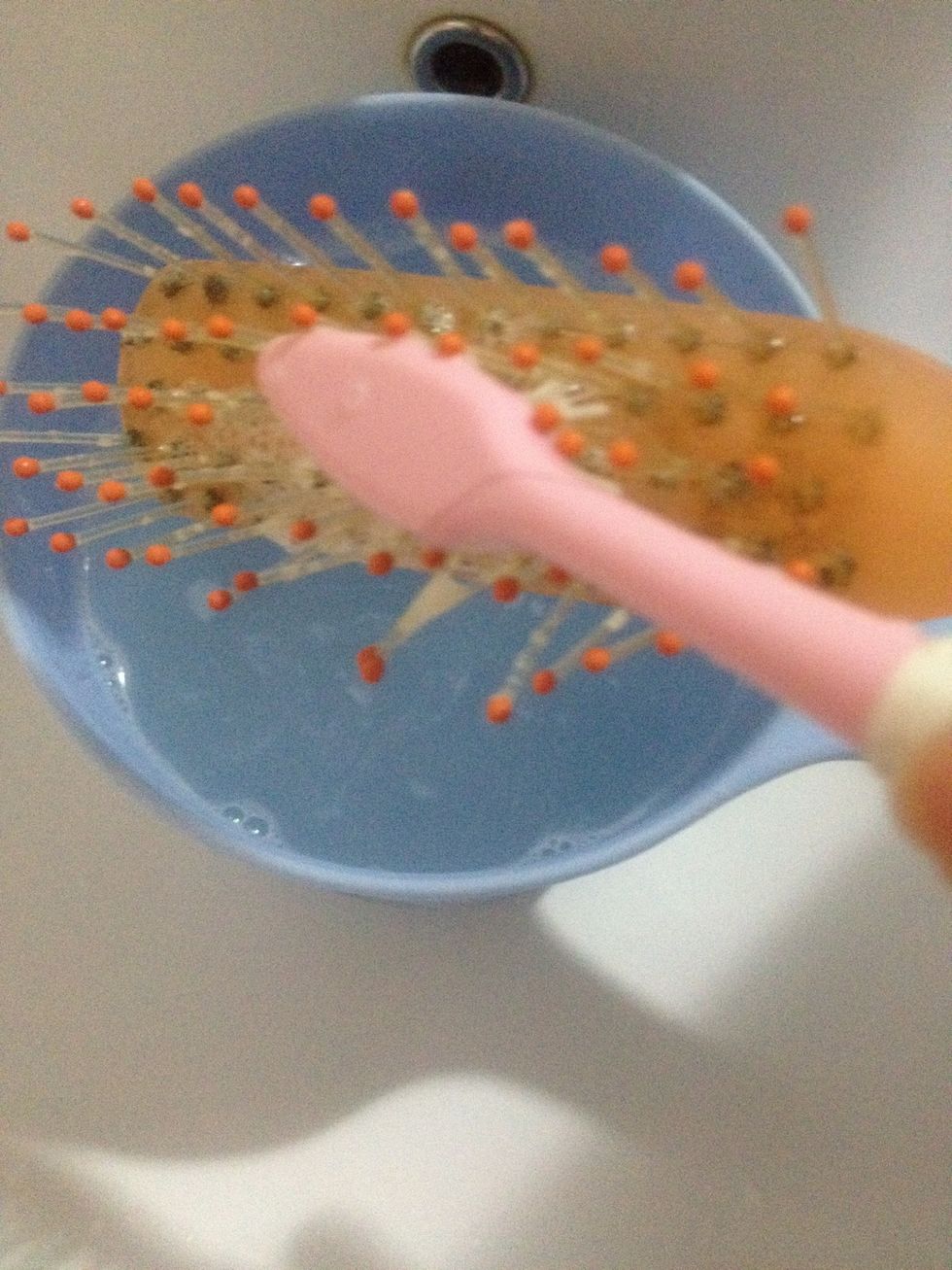 After 10 minutes in the hot water, put your shampoo around the bucket or straight to the hairbrush, and scrub it with your old teethbrush.