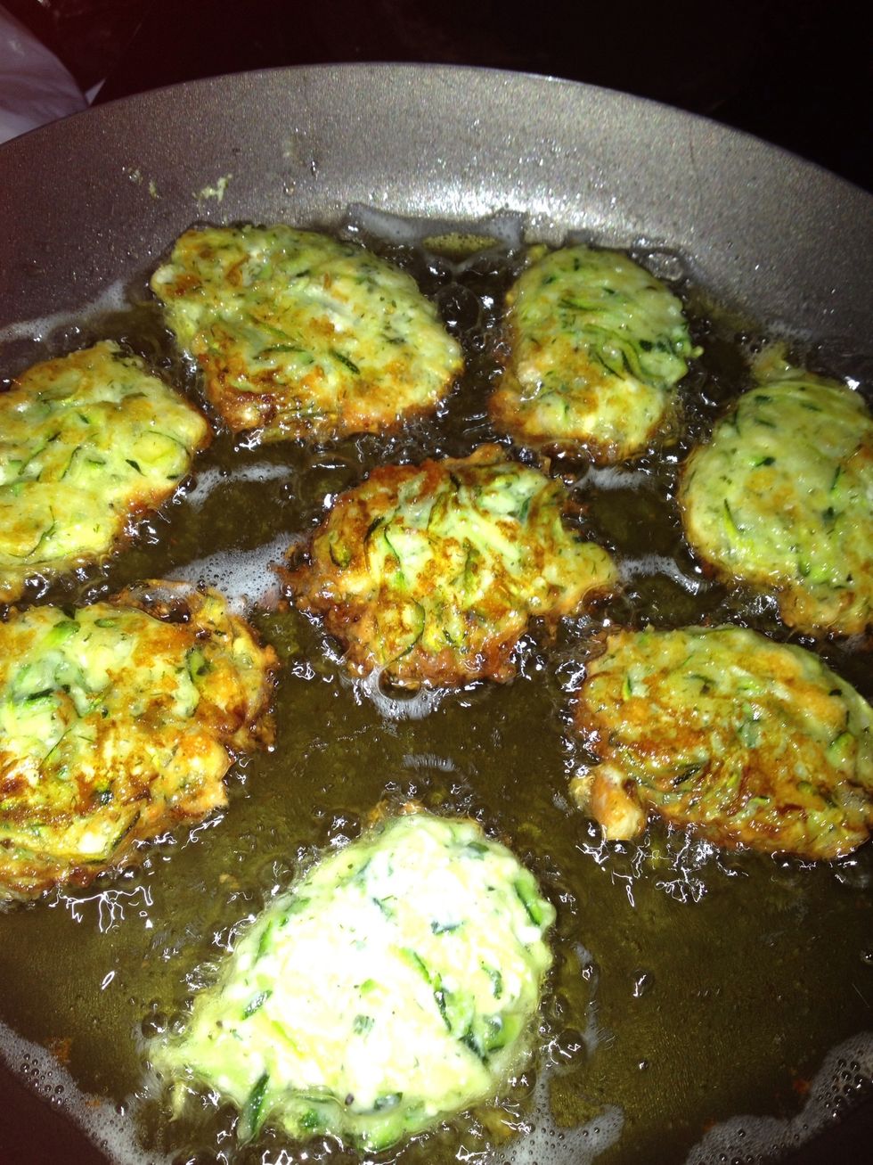 After 2-3 minutes, the edges will start browning. That's not very visible, gently slide a fork under one fritter and turn over. If nicely browned, turn the others over too, it should look like the pic