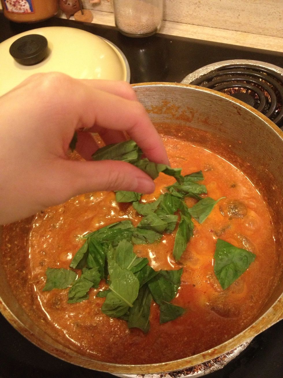 After 20 min, add freshly torn basil and stir. You can now turn off heat and keep lid on until pasta is ready.