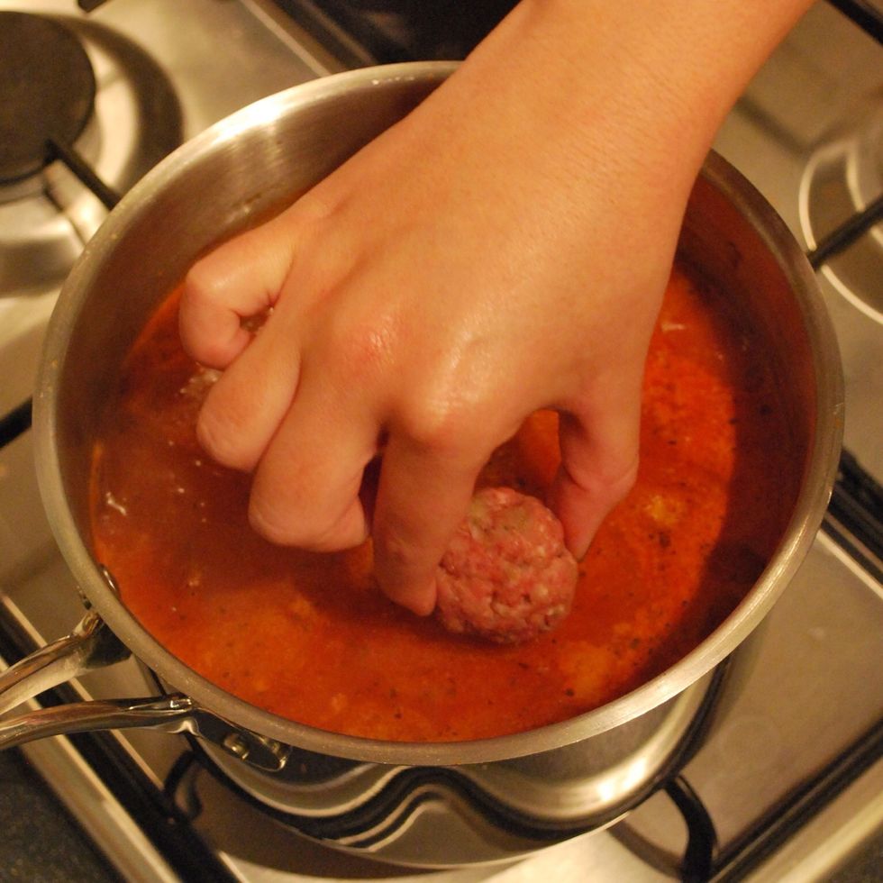 After 20 mins, add the milk to the pan, stir and then gently lower each meatball into the sauce. Jiggle the pan to make more space, don't stir or prod and poke as you might break the meatballs