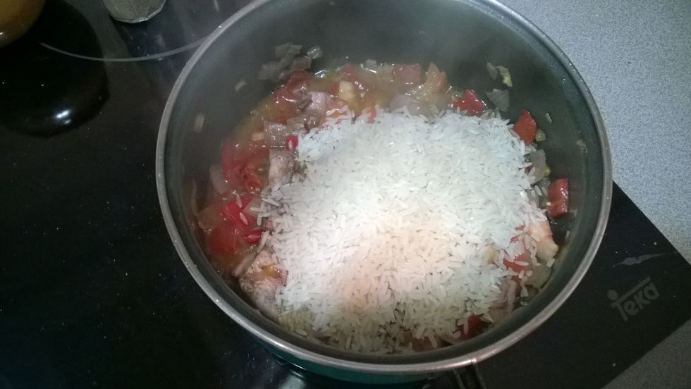 After 3 minutes, add the rice; stir well (for 1 minute) allowing to mix all the ingredients. Inmediately add the hot water (more or less, four times the meassure of the rice).